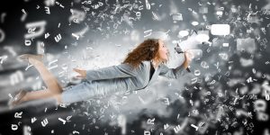 Businesswoman with a megaphone flying in a cloud of her own words